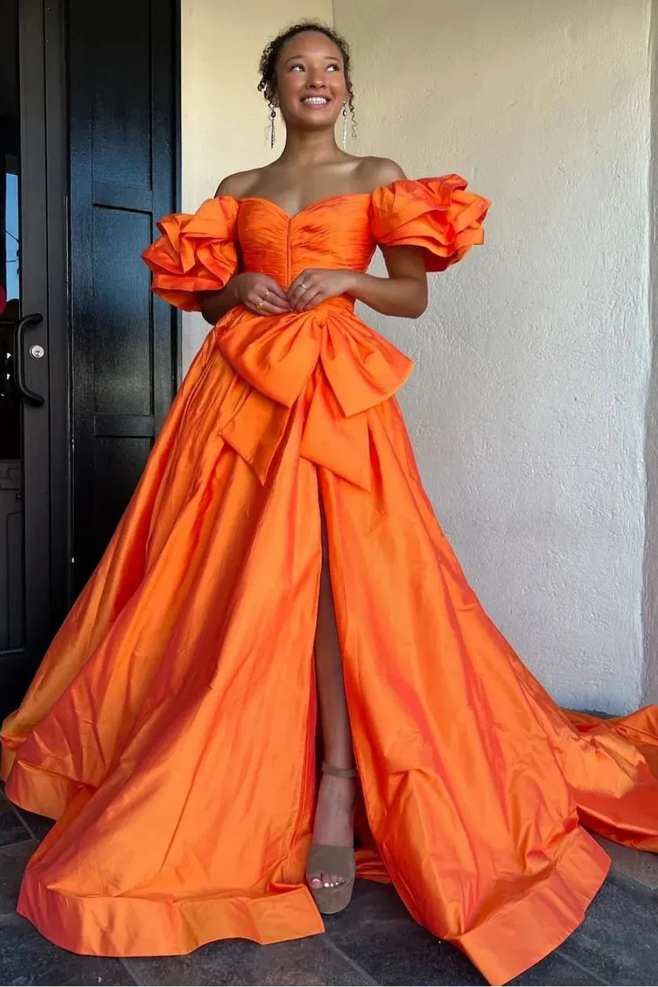 orange off-shoulder gown with ruffled details.