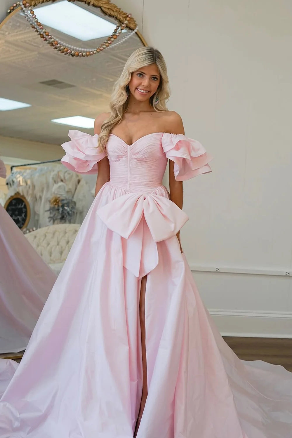 pink off-shoulder evening gown with a large bow