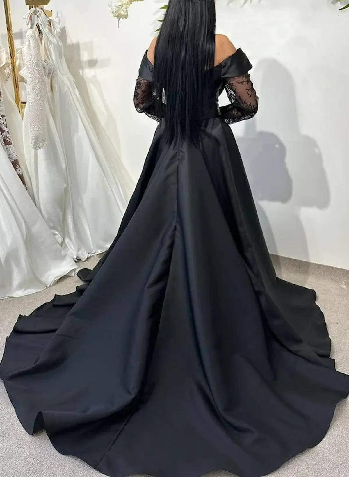 off shoulder black ball gown with sheer lace sleeves and a full train