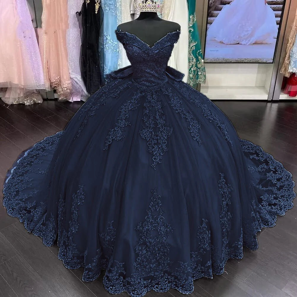 A navy blue quinceanera dress with floral lace applique and an off-shoulder neckline