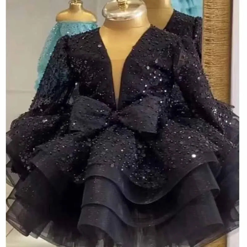 A black long-sleeve party dress with sequins and a large bow