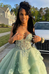 Woman in a light green formal gown with floral details